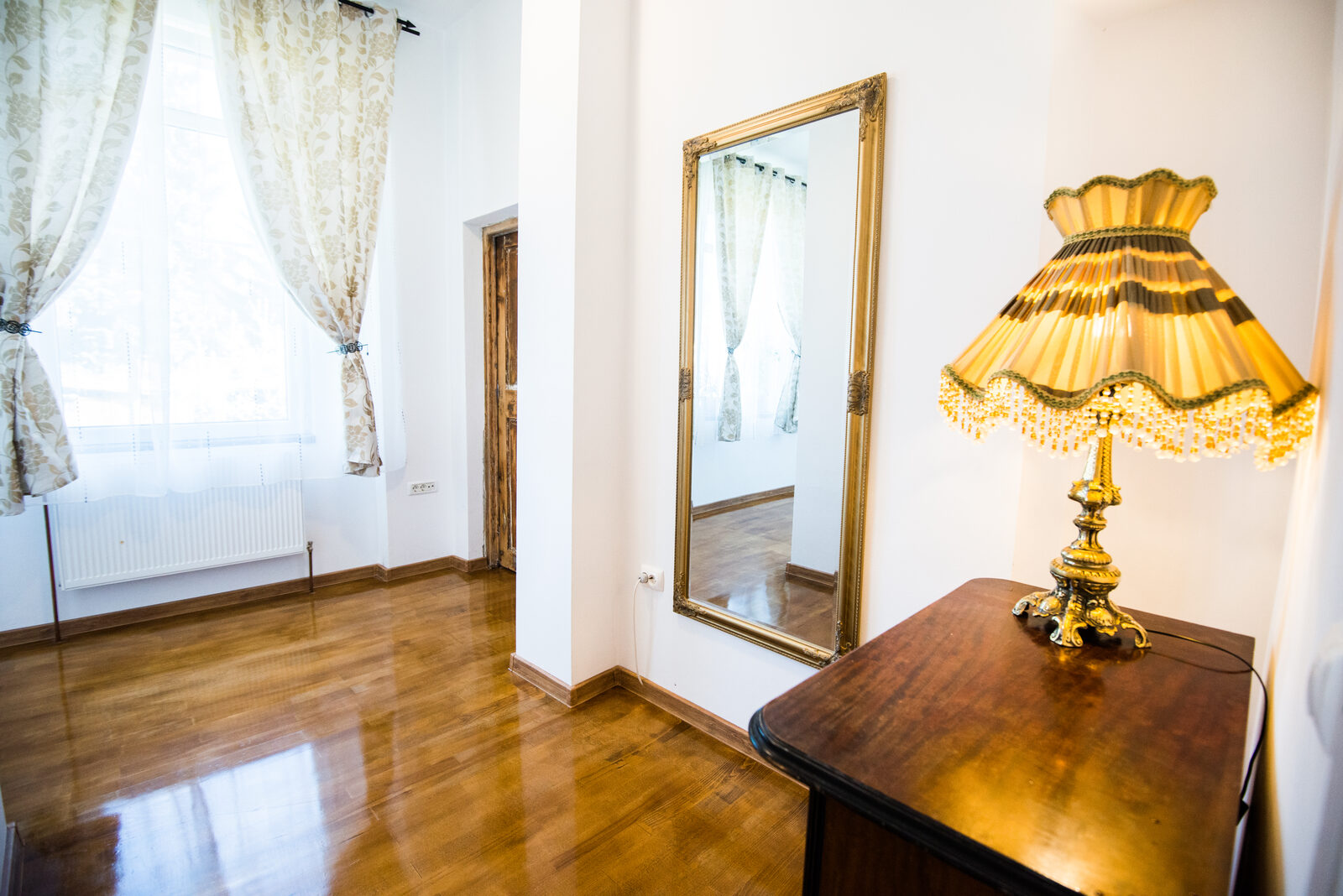 Oglinda aurie, lampa antica de fonta si parchet masiv de stejar